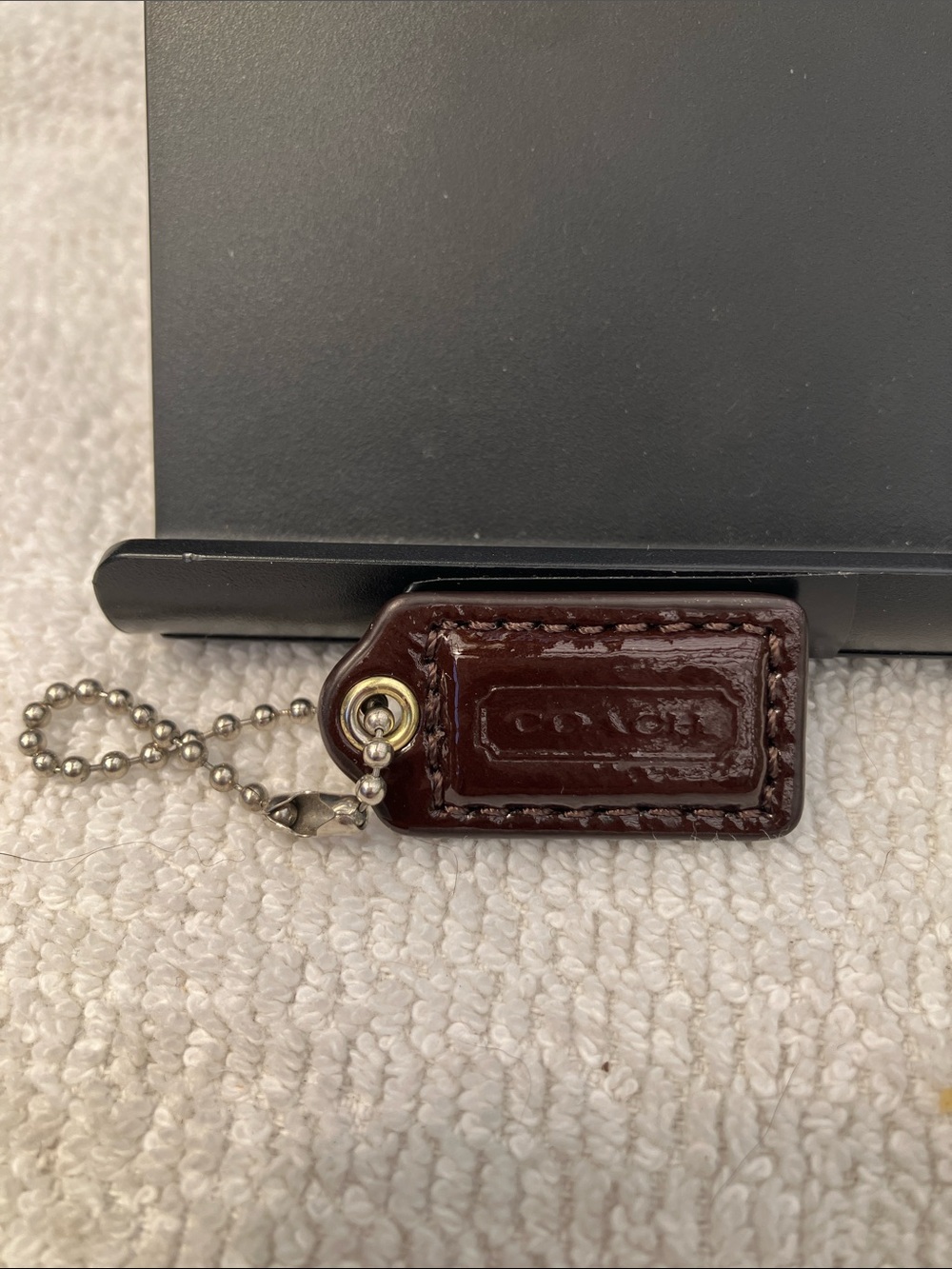 Coach Small 1-1/4” brown patent leather hang tag